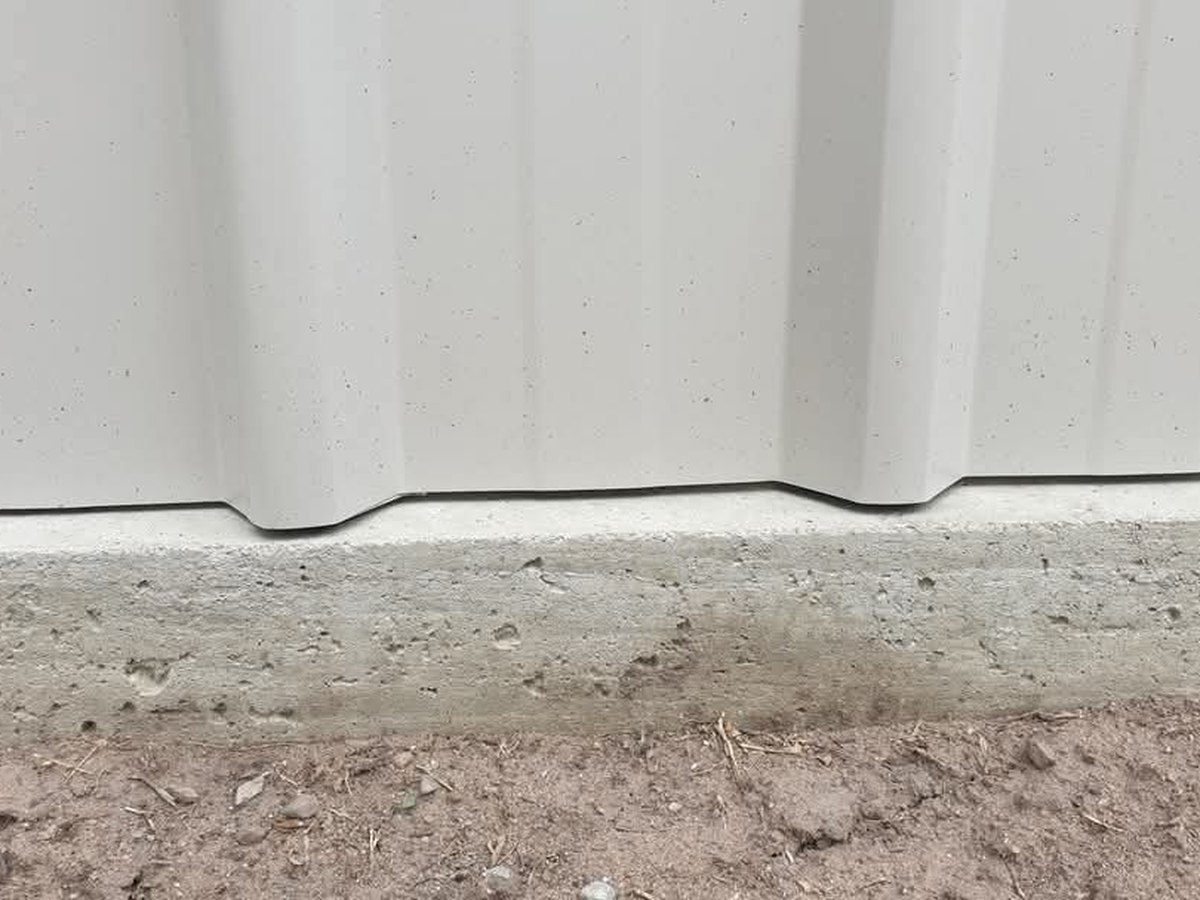 Wall sheeting seated into a cast-in concrete vermin rebate on a Spartan Sheds™ slab